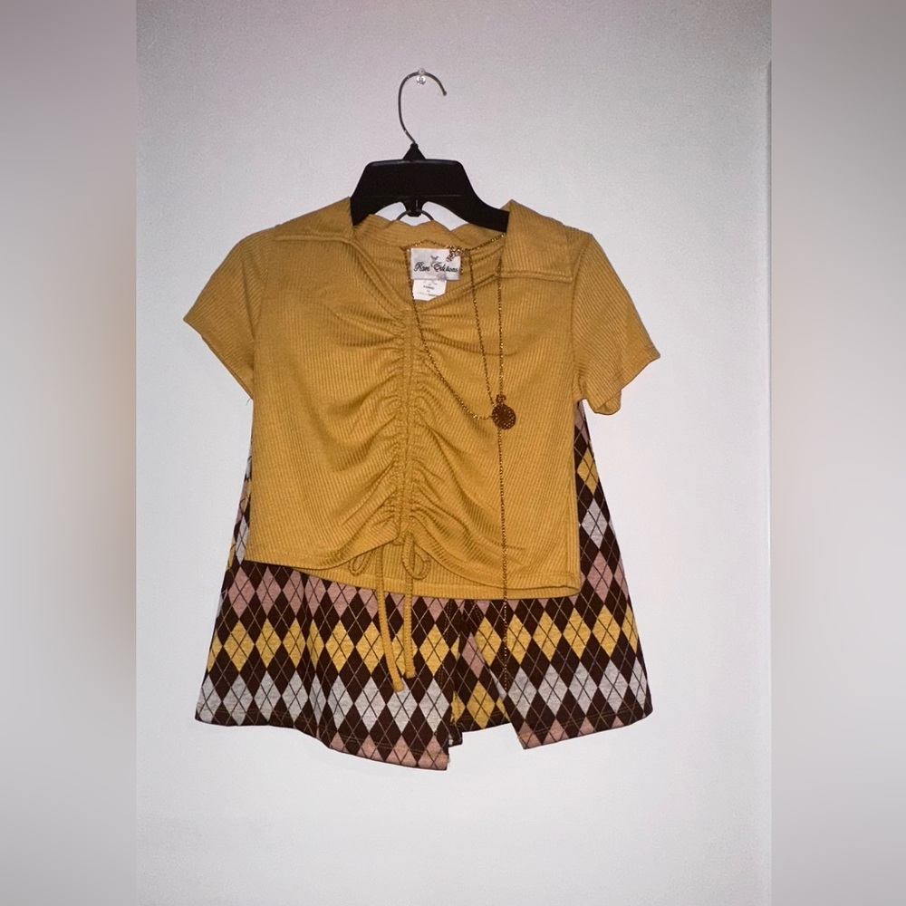 Causal two piece skirt set with gold chain accessory.